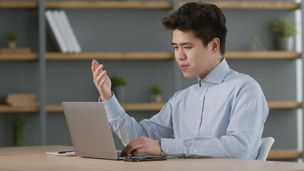 Young asian office worker video conferencing with foreign partners via laptop chat, sitting at cozy office, free space