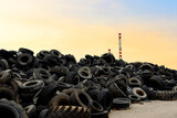 Fototapeta  - Waste tires and tyres at landfill for recycling. Regenerated tire rubber produced. Reuse of the waste rubber tyres. Pile of old wheels for recycling. Disposal of waste tires. Tyre dump
