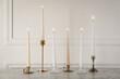 Elegant candlesticks with burning candles on white marble table