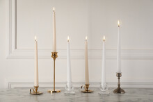 Elegant Candlesticks With Burning Candles On White Marble Table