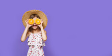 Happy Little Girl In Summer Dress And Straw Hat Holding An Orange On A Yellow Background With Space For Text. 