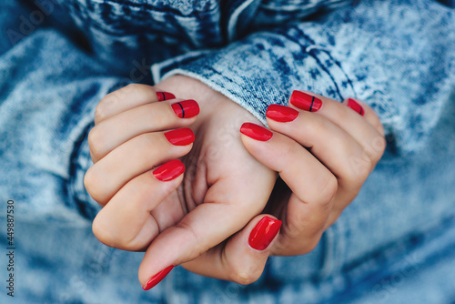 Woman hands with nail polish. Hipster girl wearing denim jacket, street style.