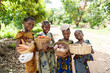 Group of pretty smiling African girls carrying baskets full of vegetables, on their way to the lokal market
