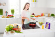 © deagreez - Portrait of attractive cheerful girl cooking tasty yummy homemade meal gourment frying dinner in light white home kitchen indoors