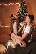 © Елизавета Старкова - The concept of Christmas. A happy man and a woman in love celebrate the winter New Year holidays at night in a cozy house. A couple in love are kissing hugging together watching a movie eating popcorn