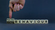 Positive or negative behaviour symbol. Businessman turns cubes, changes words negative behaviour to positive behaviour. Grey background, copy space. Business, positive or negative behaviour concept.