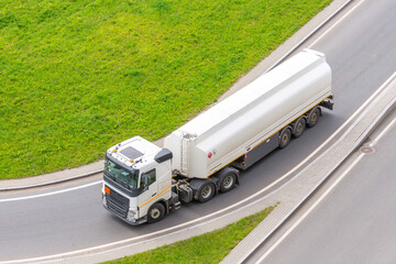 Wall Mural - Truck with tank trailer and fuel turns on city highway, aerial view.