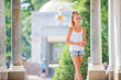 portrait of a slender young teenage girl on background of antique architecture in park