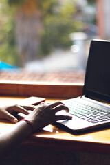 Close-up side view of female fingers typing on laptop keyboard in the meeting room