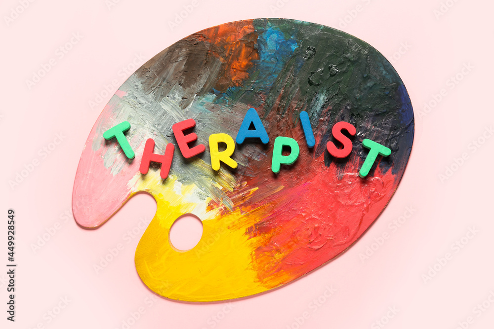 Word THERAPIST and paint palette on color background