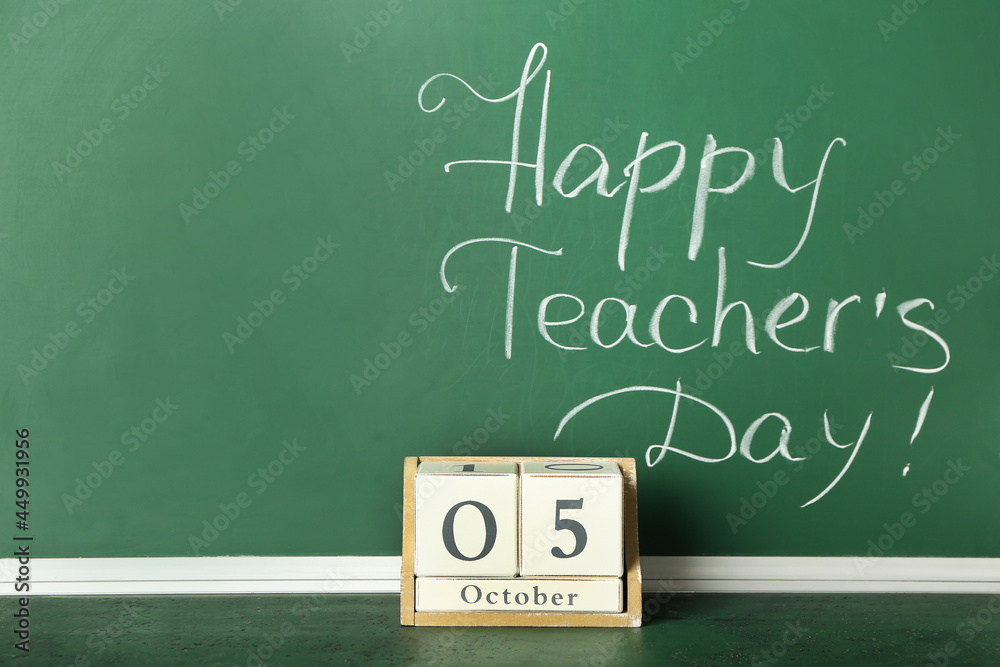 Chalkboard with text HAPPY TEACHER'S DAY and cube calendar in classroom