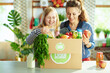 © Alliance - smiling young mother and child with food box in kitchen