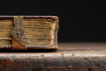 Part Of An Antique Book On A Clasp Is Visible On An Old Wooden Table, Close-up.