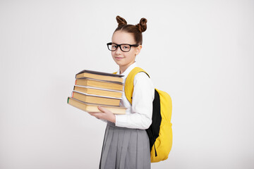 Wall Mural - cute girl in school uniform with backpack and books over white background