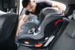 © Aleksandr - Man installs a child car seat in car at the back seat. Responsible father thought about the safety of his child