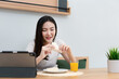 © snowing12 - Living room concept a female adult enjoying eating sandwiches and orange juice watching online media in the work break
