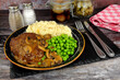 Salisbury steak meal with mashed potato, peas and mushroom sauce