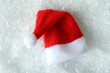 © Atlas - Red Santa hat on decorative snow background