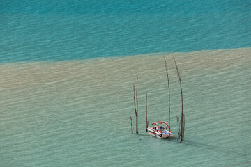 Boat turquoise water of mountain lake flooded trees . High quality photo