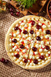 Cherry Cheese Pizza - homemade dessert pizza is made with a buttery dough, cherry and cream cheese. Sweet pizza on paper with ripe sweet cherry and wooden plate. Dessert lunch in rustic style.