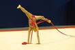 Gimnastyka artystyczna dziewczyna robi szpagat w pokazie z wstążkami