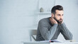 © LIGHTFIELD STUDIOS - stressed man looking away near calculator on table