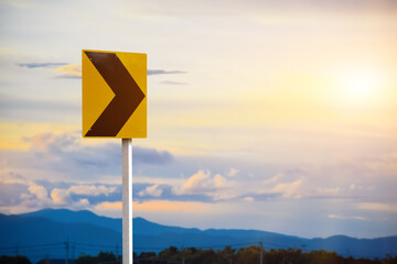 Right chevron traffic sign, this sign warns you of a change in direction or narrowing of the road. You may find these signs on the outside of a sharp curve or on approaches to a narrow bridge.