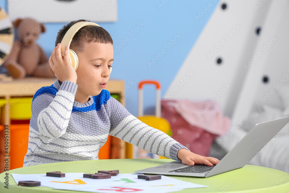 Little boy with laptop training pronounce letters at home