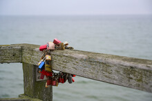 Chain Of Padlocks On A Wooden Fence By The Ocean