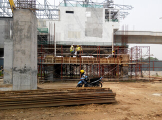 Wall Mural - PENANG, MALAYSIA -JUNE 18, 2021: Structural works are underway at the construction site. Construction workers are installing formwork made of metal or timber. Safety features are paramount.
