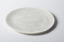 High Angle Of Simple Round Plate With Marble Enamel Placed On Gray Table