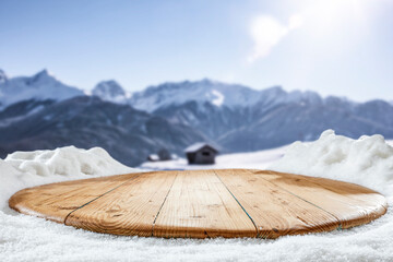 Wall Mural - fresh snow on a wooden table on a beautiful winter day with a landscape background