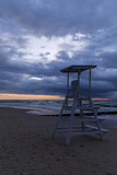 Fototapeta Miasta - cloudy sunset over the sea and lifeguard stand