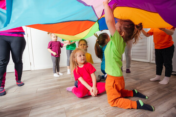 Canvas Print - Close up view of children under huge rainbow cover