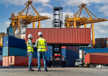 Engineers Are Overseeing The Transportation Of Cargo With Containers Inside The Warehouse. Container In Export And Import Business And Logistics.