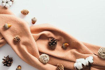 Wall Mural - Autumn flat lay composition with brown scarf, pine cones, cotton, acorns on white background. Top view, overhead