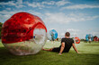 Player looking on Bubble Football. Zorbing bumper football soccer on a green field