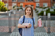 © Тарас Нагирняк - Young pupil kid girl standing near school with backpack holding lunchbox and thermos
