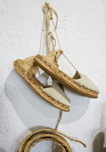 Pair Of Espadrilles Made Of Esparto Halfah Grass Or Esparto Grass. Hanging On A White Wall
