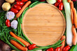  Drewniana taca otoczona warzywami. Składniki potraw wegetariańskich, produkty organiczne. Tło kulinarne