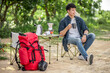 © Johnstocker - Young man relax with coffee at nature park during camping