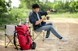 © Johnstocker - Young man relax with coffee at nature park during camping
