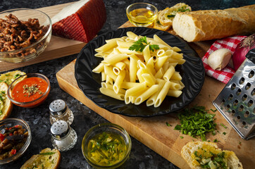 Wall Mural - High angle shot of a plate of pasta with spices and sauces on the side