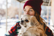 Girl walks with a dog Tibetan spaniel on a street. Selective focus, blurred background. Cold weather