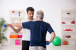 © Elnur - Young male instructor and old man doing sport exercises