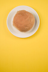 Wall Mural - Vertical shot of a tasty bun on a yellow background