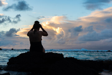 Silhouette of a woman on the ocean rocks