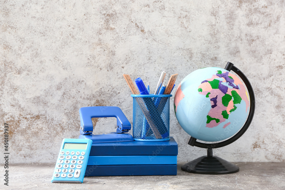 Globe and stationery supplies on grunge background