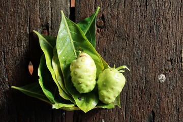 Canvas Print - Close up of noni tropical fruit on wood background