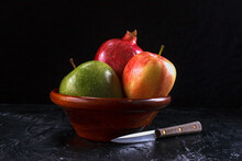 A Fine Art Image Of Delicious Looking Pomegranate And Apples In A Bowl And A Knife.
